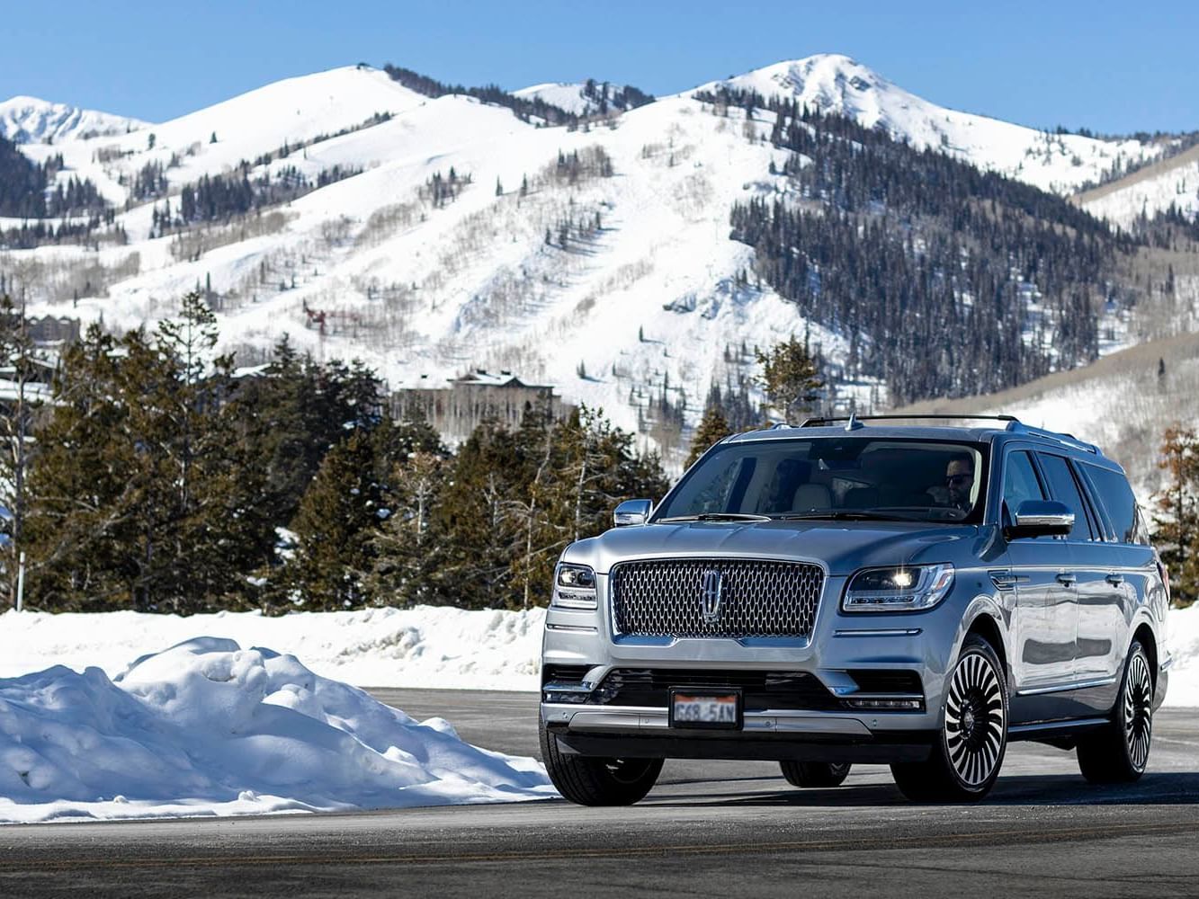 A Lincon SUV on a road near Stein Eriksen Residences