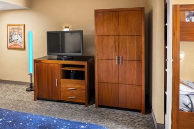TV stand with wood cupboard in Galaxy Suite at Anaheim Portofino Inn, a hotel in Anaheim with shuttle to Disneyland resort