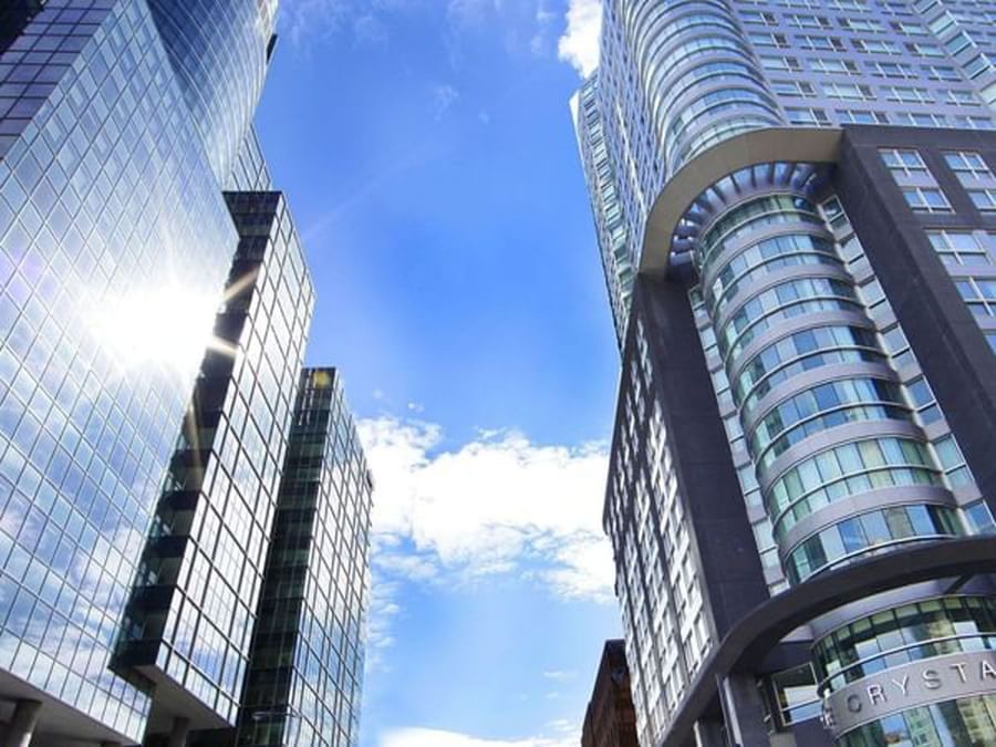 Low angle of sleek glass skyscrapers under a bright blue sky at Warwick Le Crystal Montreal