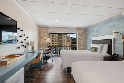 Modern Double Queen with Balcony at The Riverwalk Plaza Hotel featuring two beds, a desk, city-view, and stylish decor