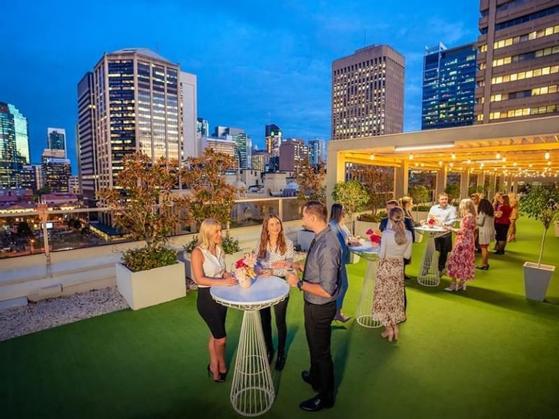 Rooftop gathering with people chatting in Soiree Deck at Sofitel Brisbane Central