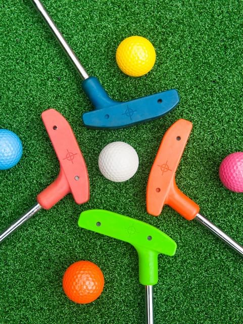 Colorful miniature golf clubs and balls arranged on the pit at Cove Pocono Resorts