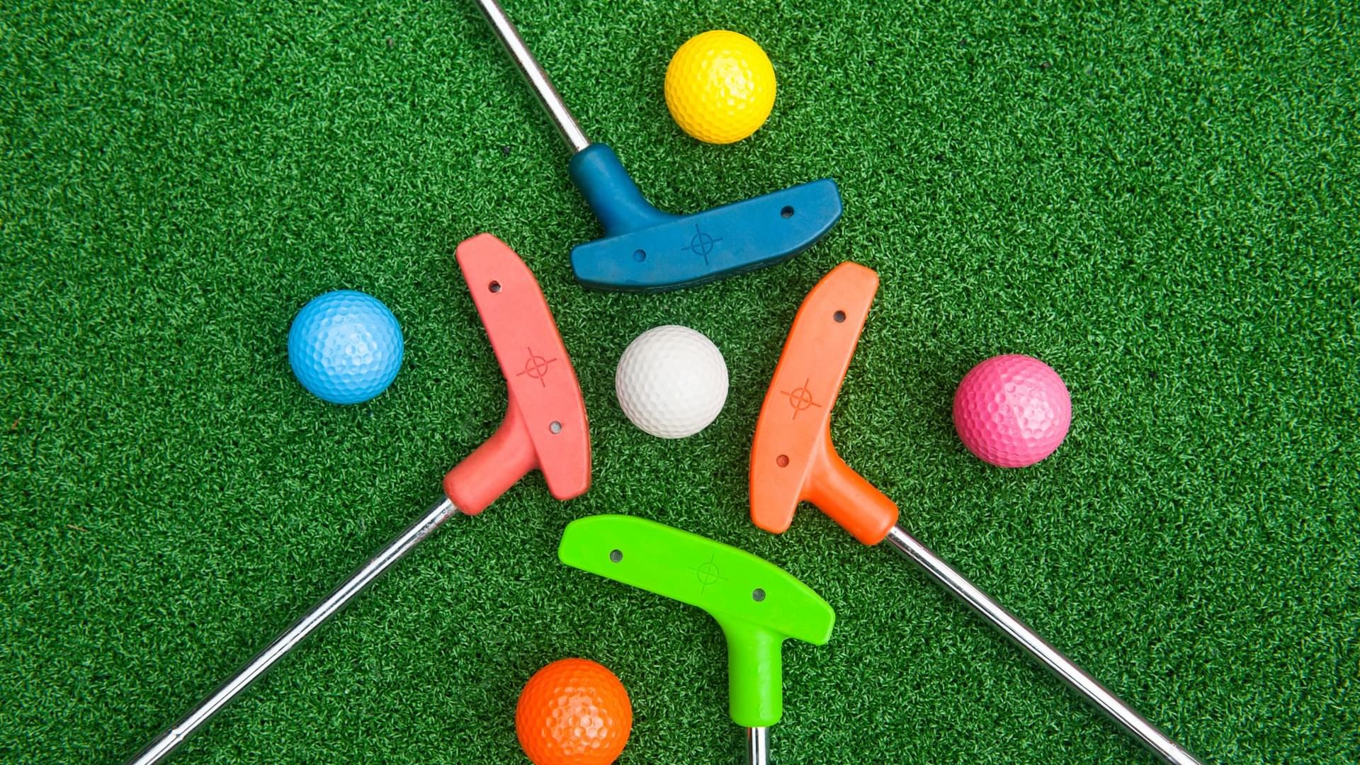 Colorful miniature golf clubs and balls arranged on the pit at Cove Pocono Resorts
