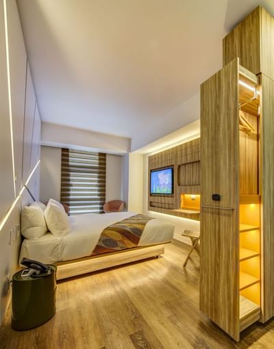 Interior of a room with wooden accents and an illuminating bed, featuring hotel rooms in Santiago Chile at Hotel Nodo
