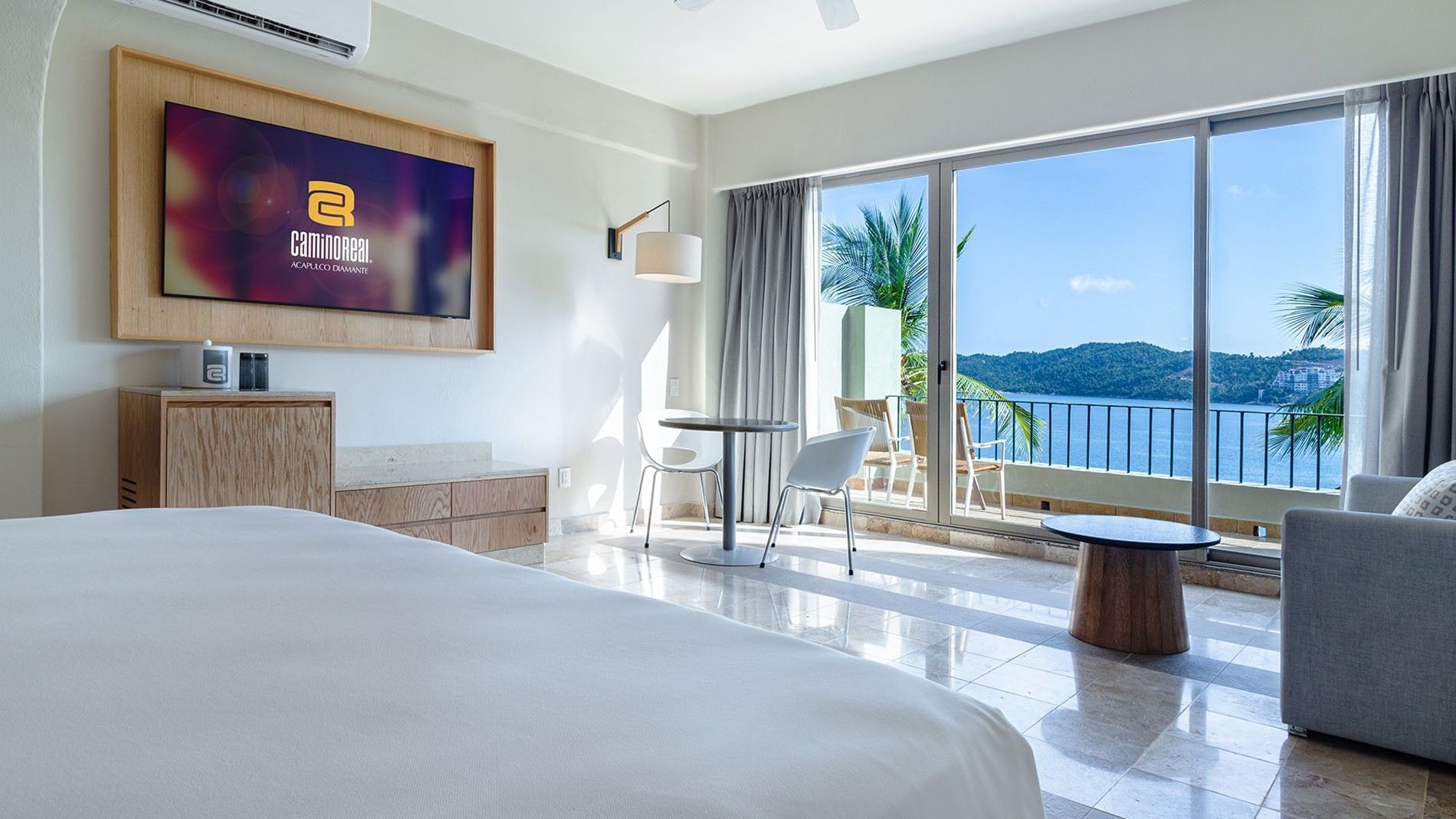 Ocean View King Deluxe Superior Room with a balcony view of the ocean and green hills at Camino Real Acapulco Diamante
