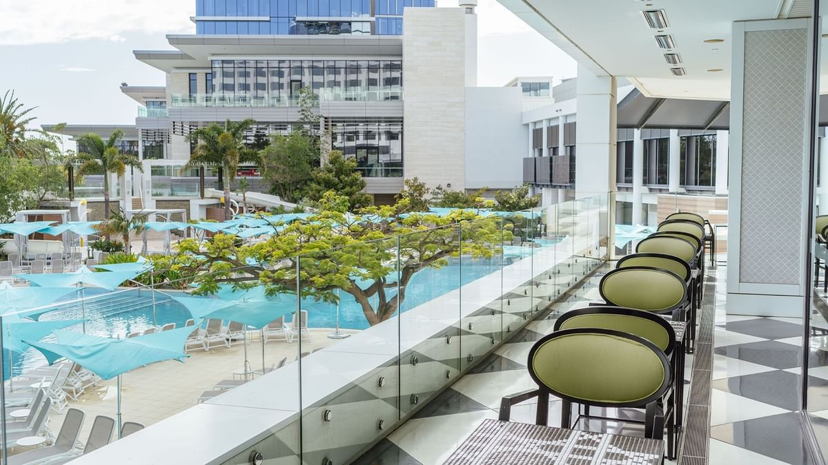Balcony view of a pool with umbrellas in Bistro Guillaume at Crown Metropol Perth