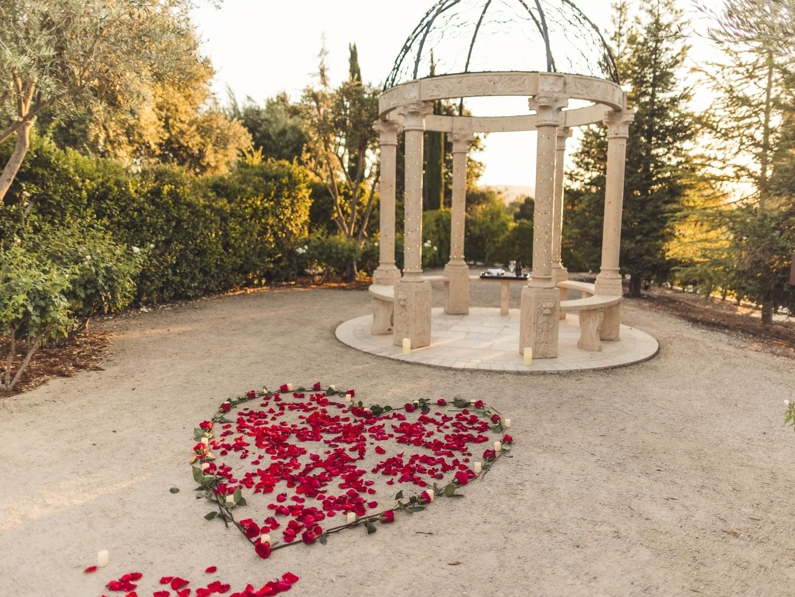 Heart shaped Rose Petals in Front of Stone Gazebo