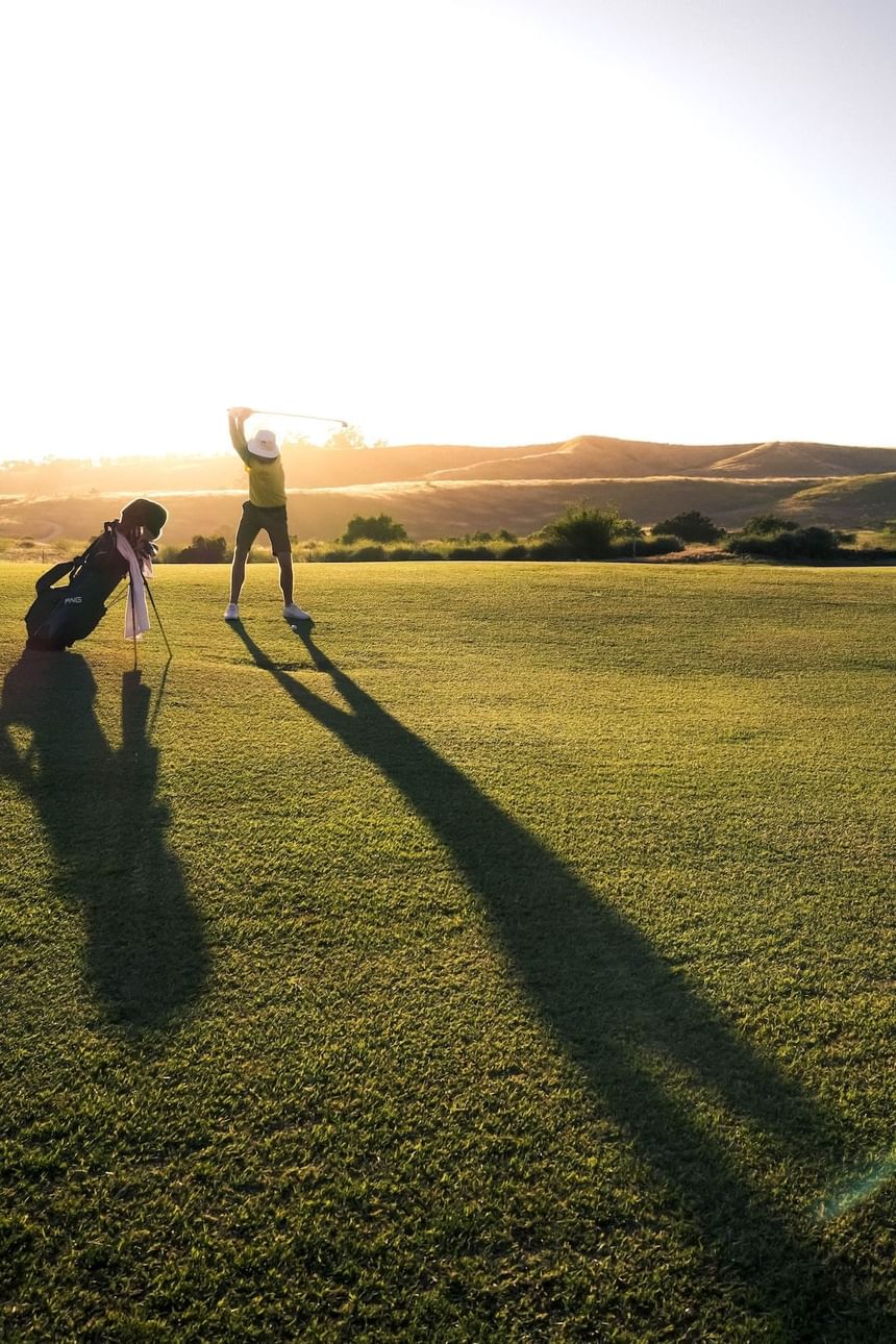 A golfer playing on golf ground at sunset near Luxe Sunset Boulevard Hotel