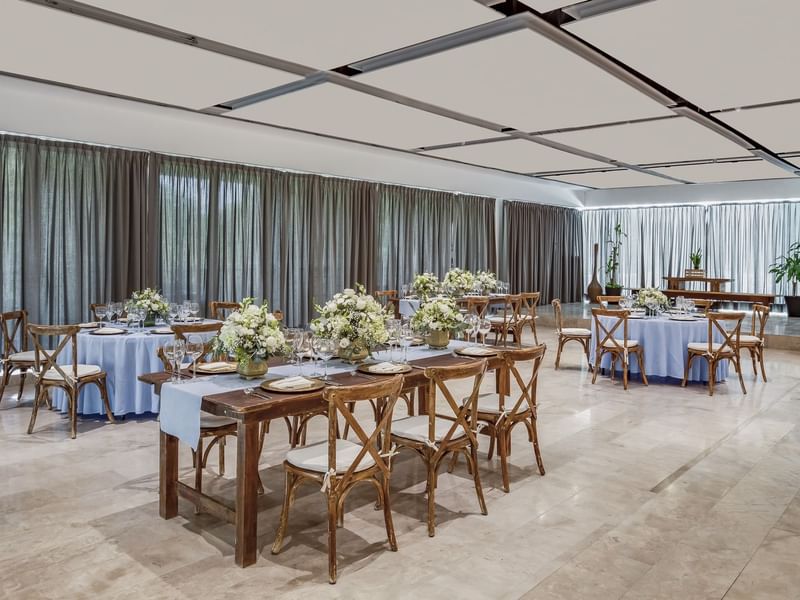 Cozumel meeting room set with elegant round and long tables and white floral arrangements at Fiesta Americana