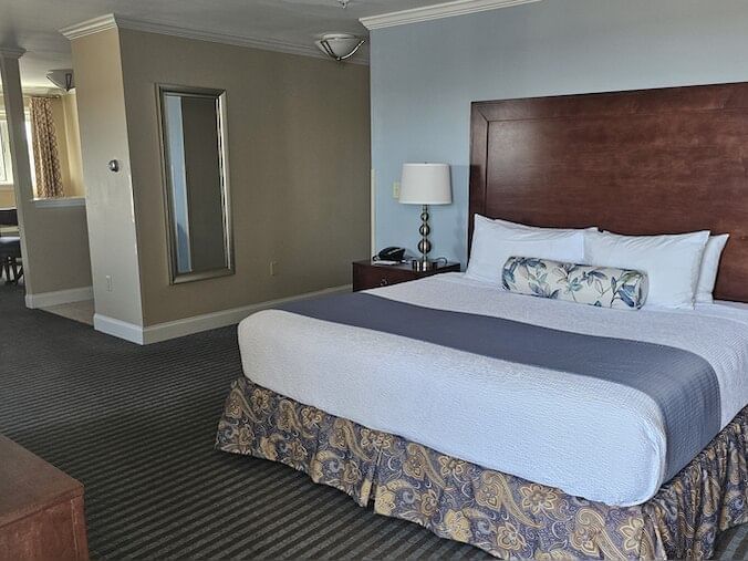 Nightstand by the bed in Deluxe King Ocean Front West Room with carpeted floors at Union Bluff Hotel