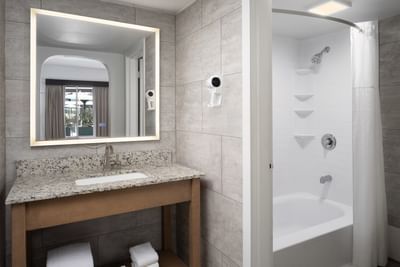 Premium Mini Suite Two Queens bathroom featuring a mirror, and a white bathtub at The Harrison Hotel Downtown Hollywood
