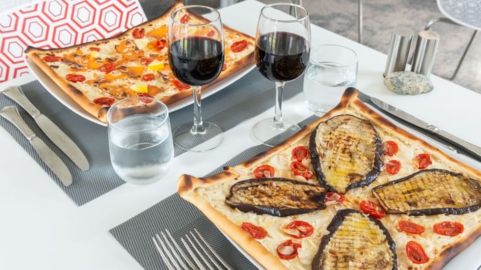 Served pizza with two glasses of wine at Ara hotel