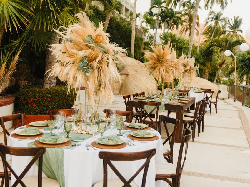 Terraces outdoor reception tables with pampas grass decor and greenery at Camino Real Acapulco Diamante