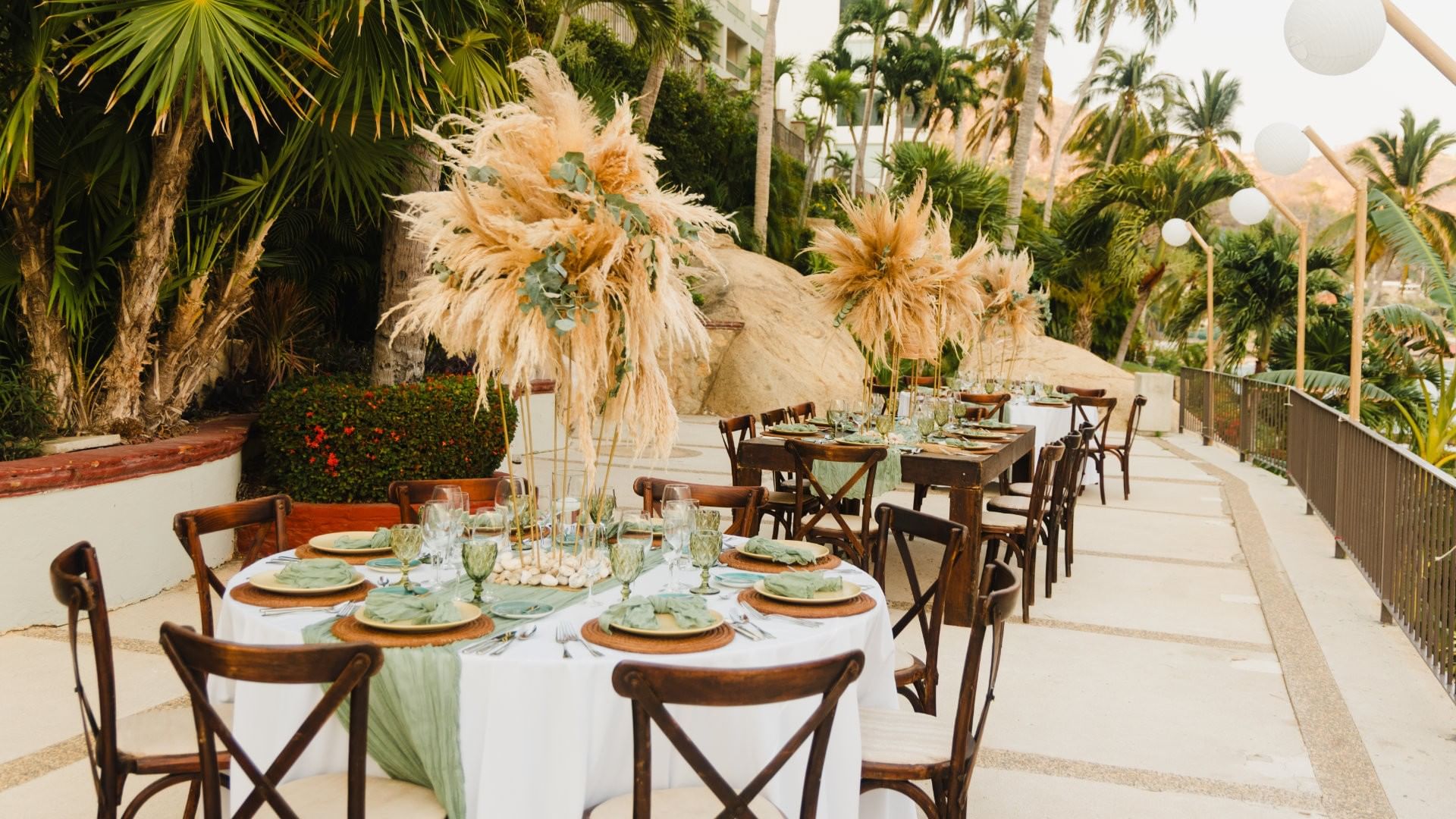 Terraces outdoor reception tables with pampas grass decor and greenery at Camino Real Acapulco Diamante