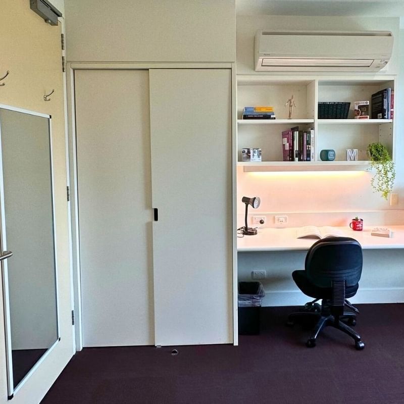 Compact room with desk, chair, and built-in shelves at La Trobe University - McFarlane's Hill Residences.