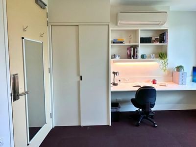 Compact room with desk, chair, and built-in shelves at La Trobe University - McFarlane's Hill Residences.