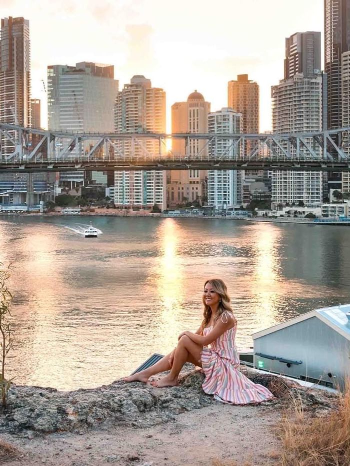 A woman sitting near a reservoir at Brisbane.