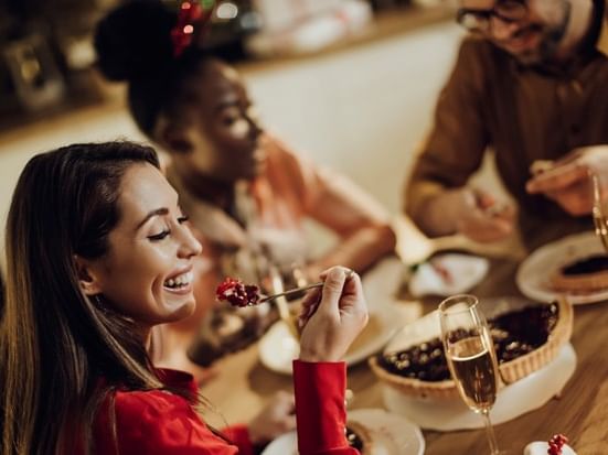 Group enjoying Christmas Eve Dinner with wine and desserts.