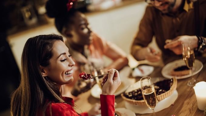 Group enjoying Christmas Eve Dinner with wine and desserts.
