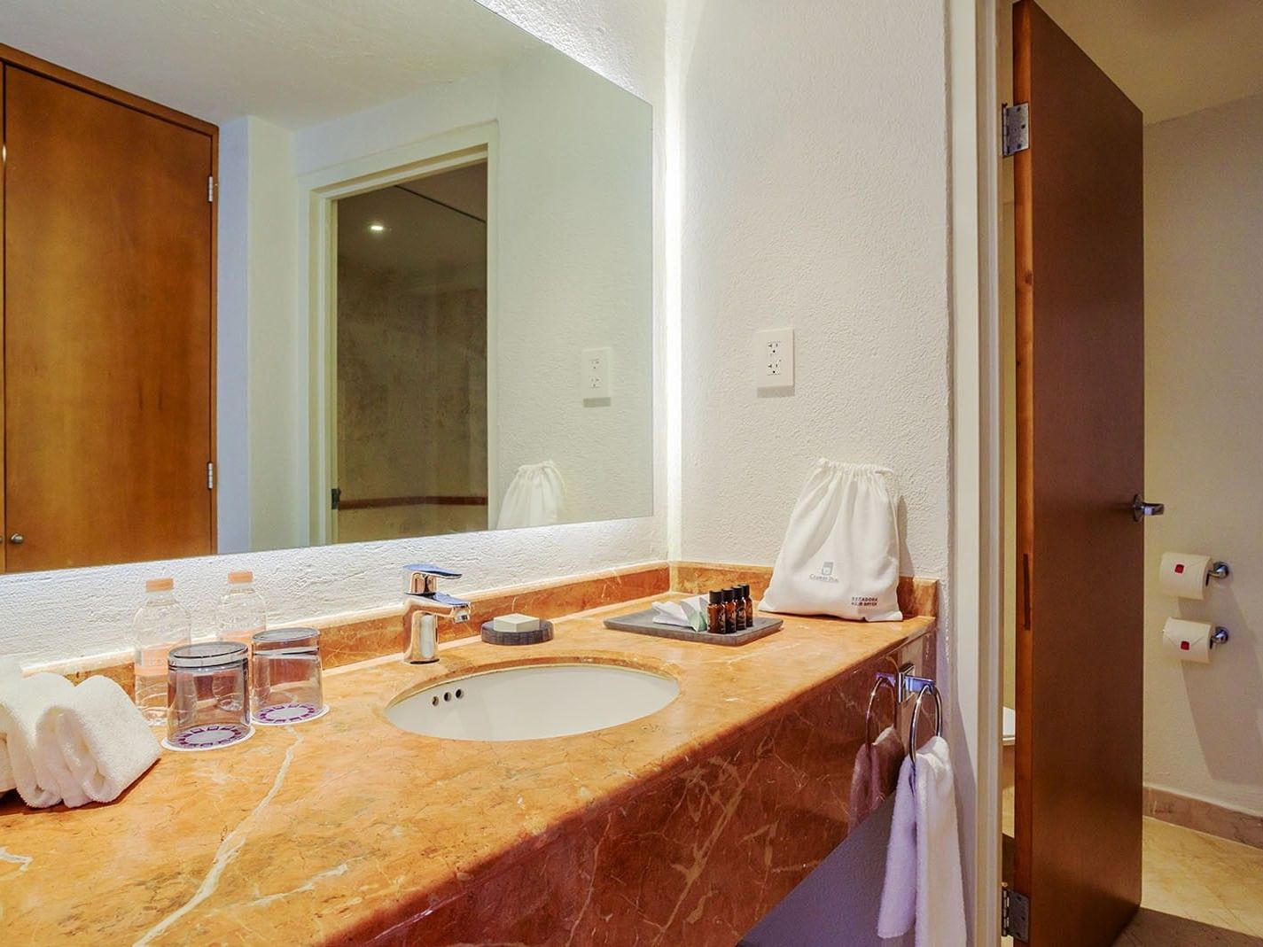 King Deluxe marble vanity with premium toiletries, fresh towels, and a large mirror at Camino Real Veracruz