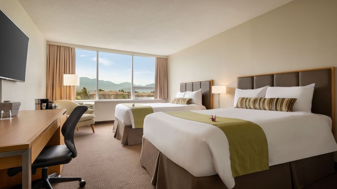 Two beds in hotel room with mountain views