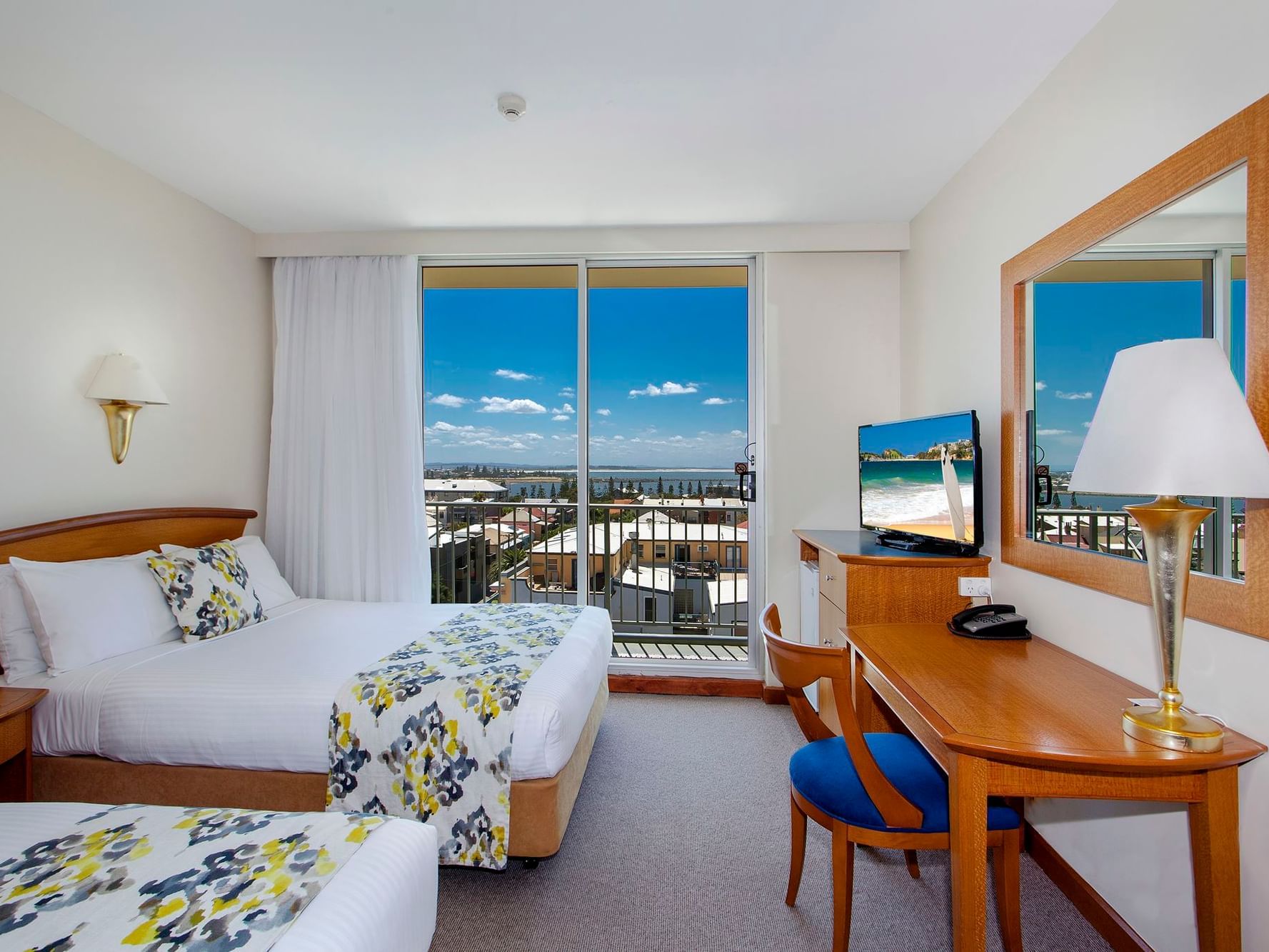 Hotel room with balcony, TV and vanity area at Noah’s on the beach