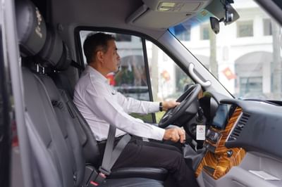 A man driving a official van of Hanoi Daewoo Hotel