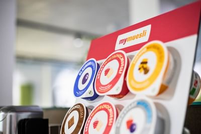 Display of various mymuesli flavors in colorful containers at the Avaneo Hotel Marktredwitz