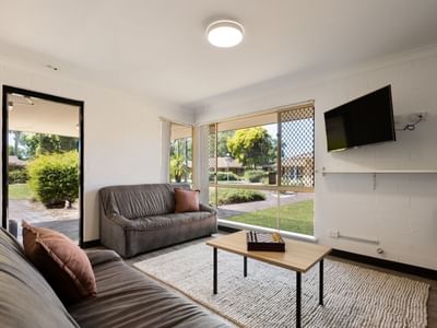 Cozy living room with two couches, a coffee table, and a TV at Vickery House.
