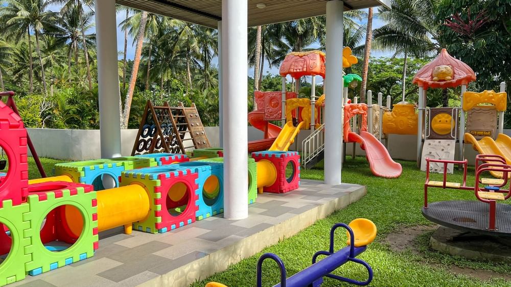 Colorful children's playground with slides, swings, and activity stations at The Naviti Resort in Korolevu.