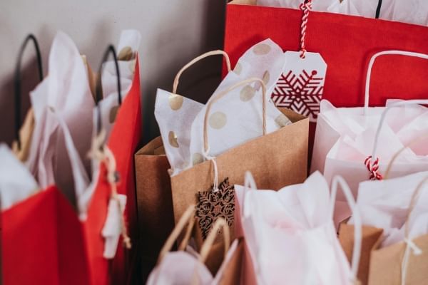 A variety of paper shopping bags, tissue paper, and gift tags. 