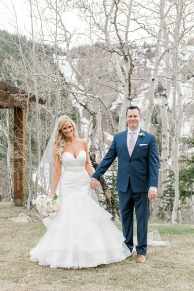 A bride & groom holding hands in outdoors of Stein Eriksen Lodge