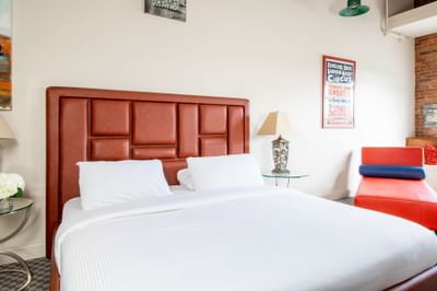 Bed with padded headboard & comfy pillows in King Premiere Urban Studio at Retro Suites Hotel