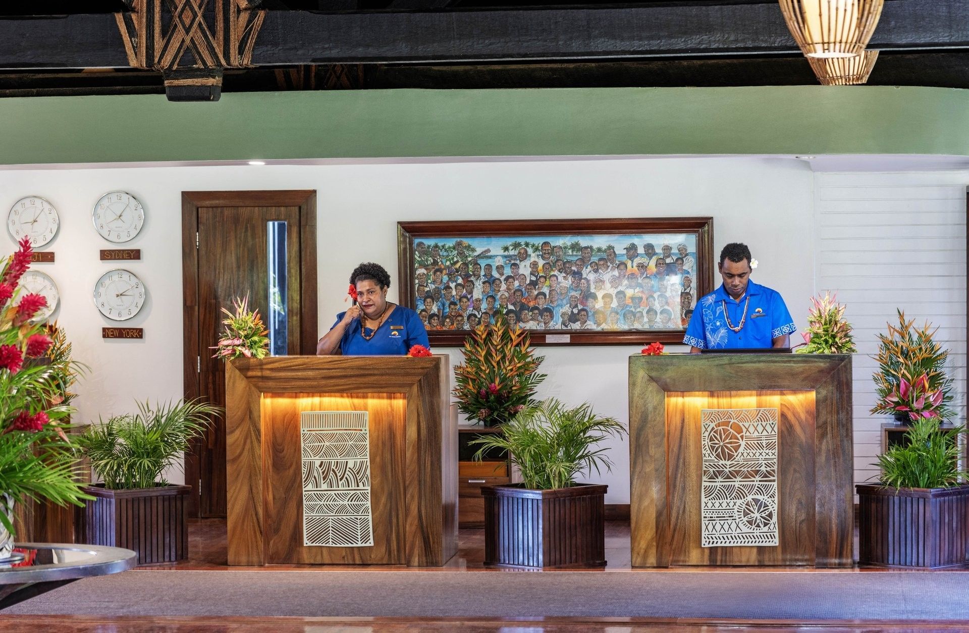 Staff with wooden desks & a group photo under world clocks in the lobby area at The Naviti Resort - Fiji