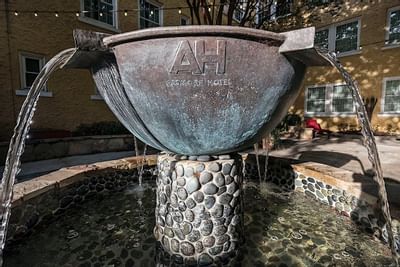 A fountain with the letters AH on it at Artmore Hotel
