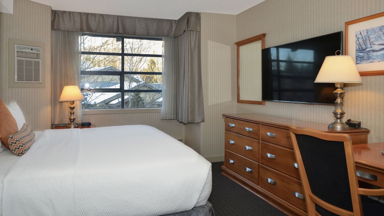 Hotel Junior Suite with king bed, HDTV and a large window.