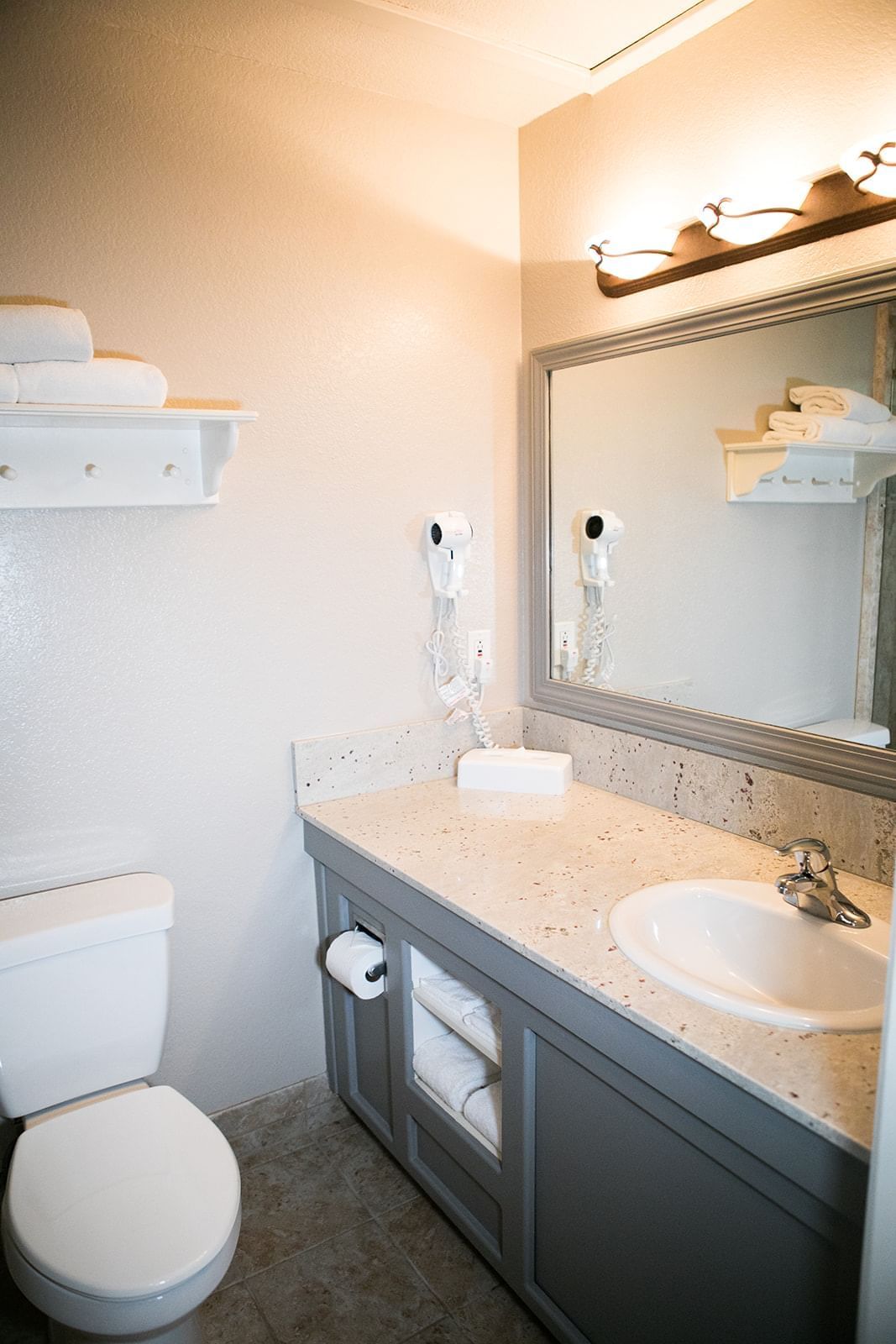 A clean bathroom with a toilet, sink, and mirror