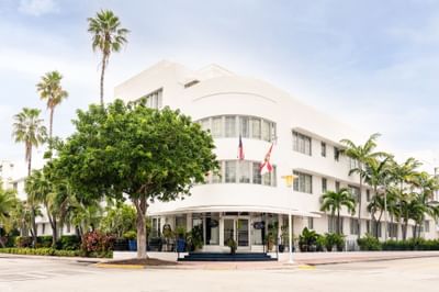 Iconic white Art Deco facade of Riviera Hotel South Beach with curved windows and lush tropical palms