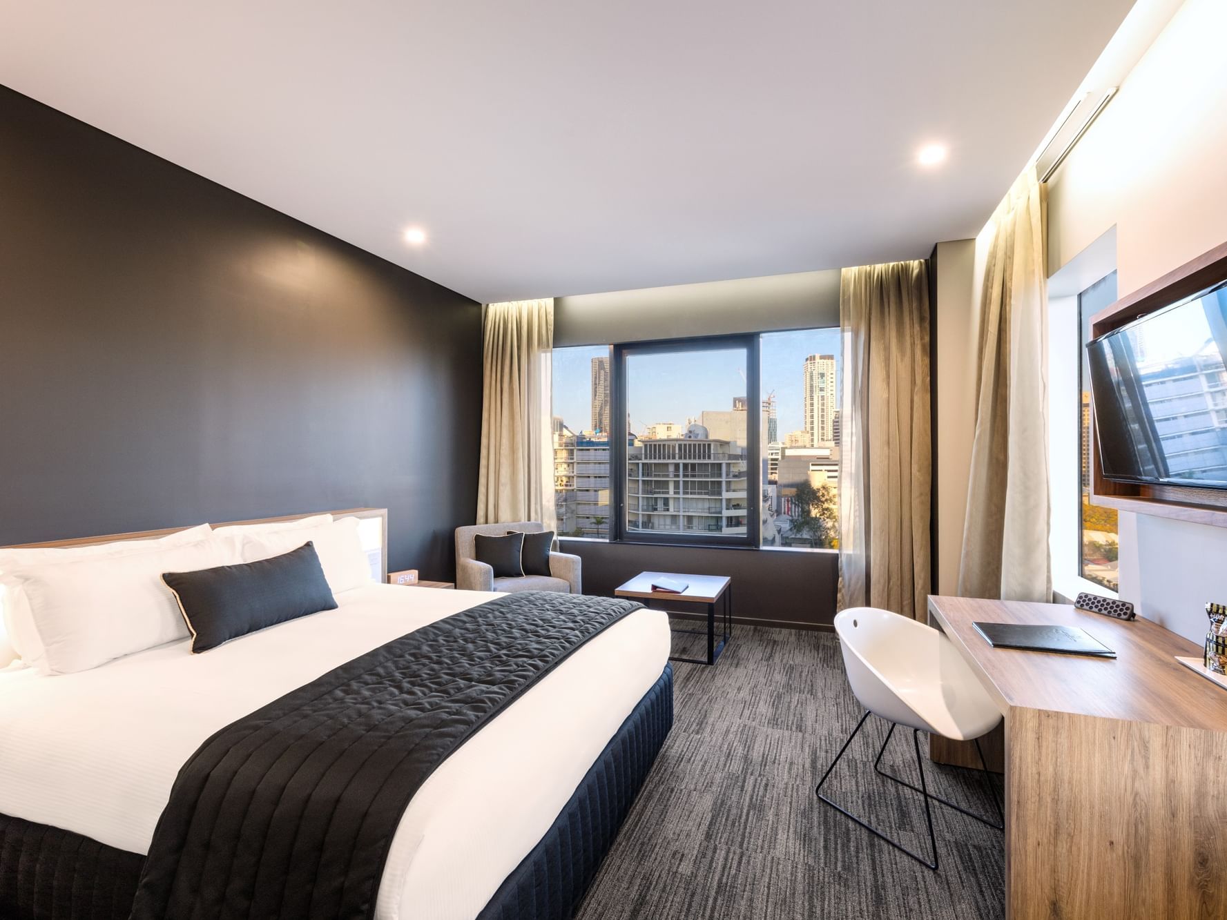 Large bed with work area and arranged sofa in Executive King Room at Hotel Grand Chancellor Brisbane