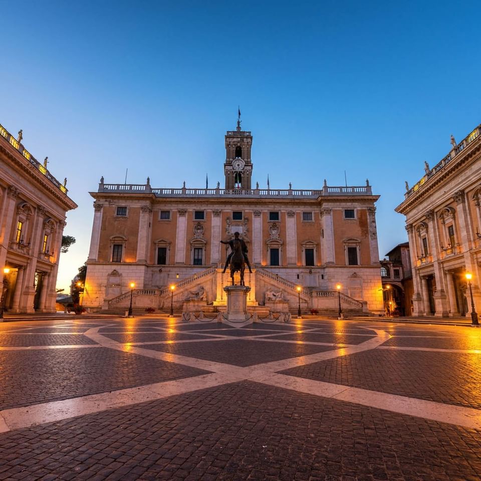 Piazza del Campidoglio with Marcus Aurelius' statue, historic buildings, and a sunset sky near The Independent