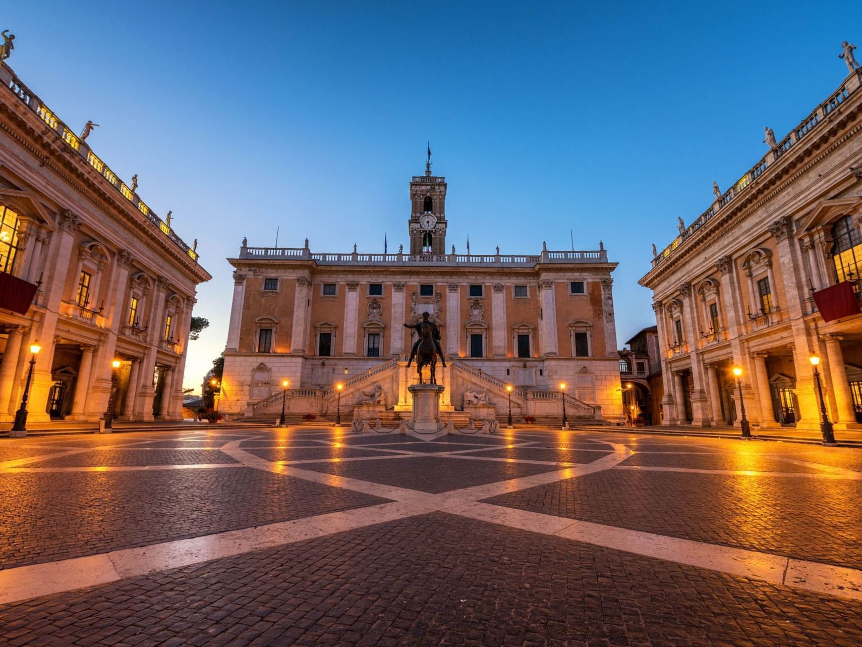 Piazza del Campidoglio with Marcus Aurelius' statue, historic buildings, and a sunset sky near The Independent