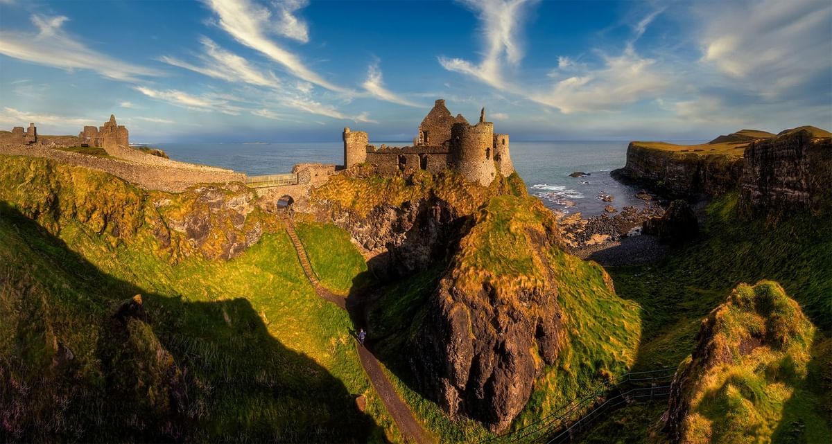 Aerial view of Dunluce Castle in the sun set near Dunluce Lodge