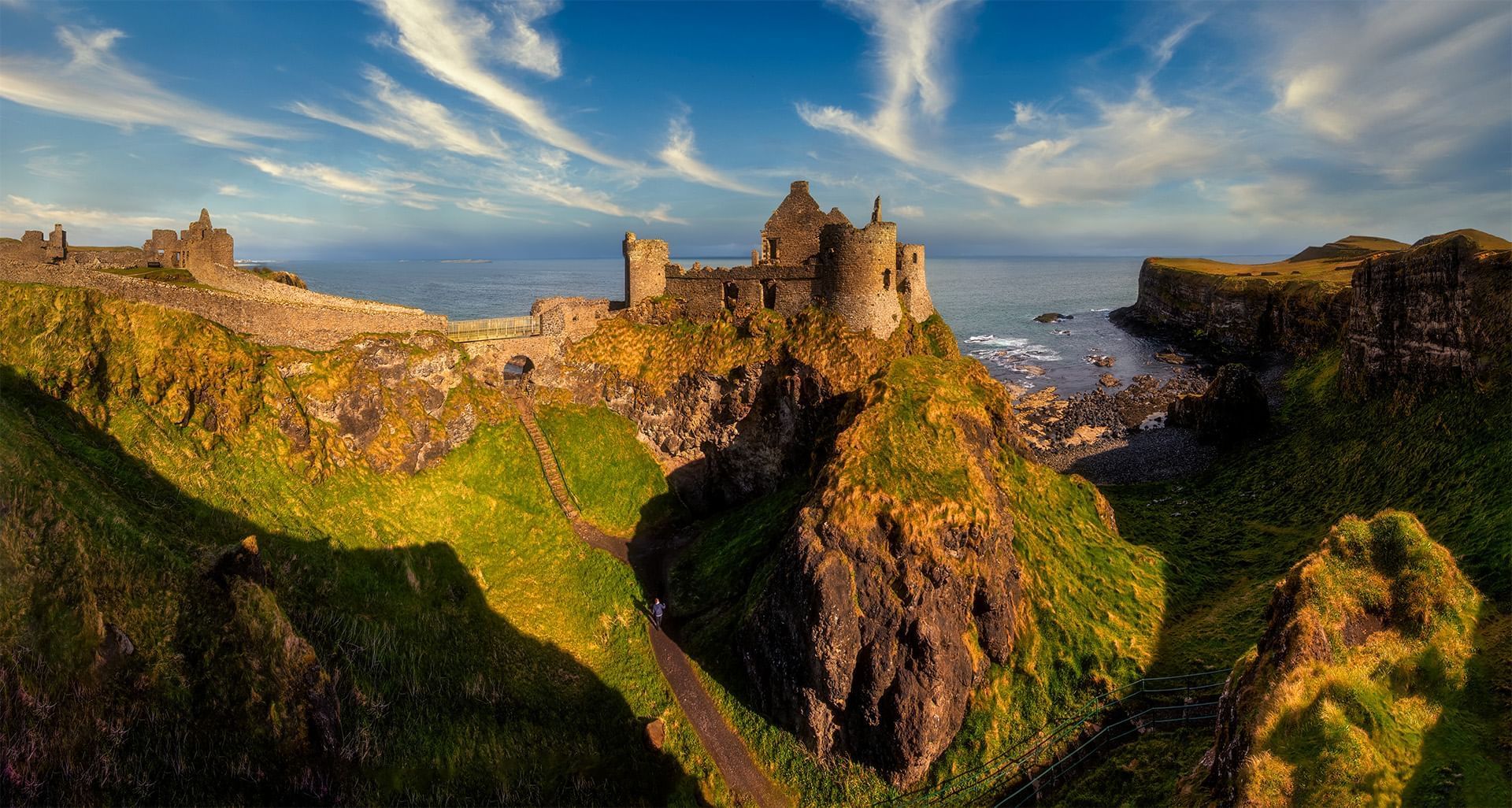 Aerial view of Dunluce Castle in the sun set near Dunluce Lodge