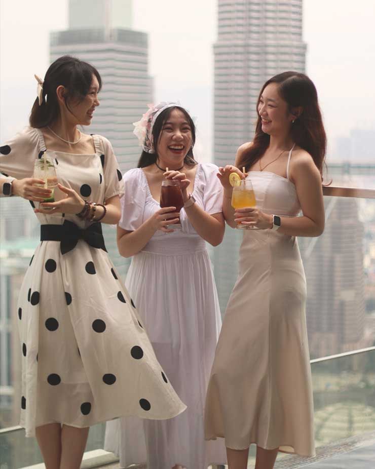 Ladies enjoying cocktails on the terrace with a city backdrop at Imperial Lexis Kuala Lumpur