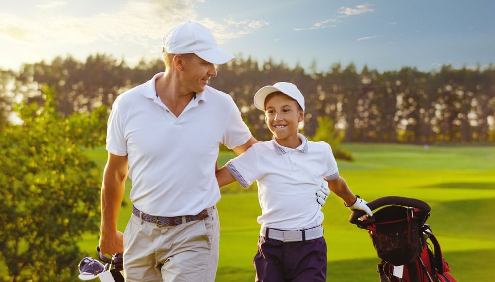 Father & son walking at golf course near Lake Buena Vista Resort Village & Spa