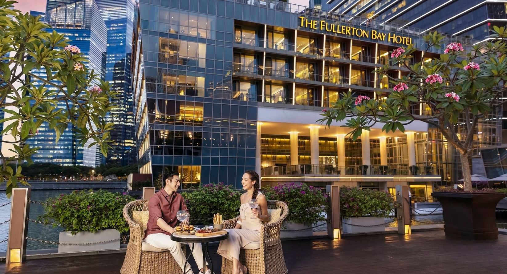 A couple enjoying dinner in the outdoor dining area at The Fullerton Bay Hotel Singapore