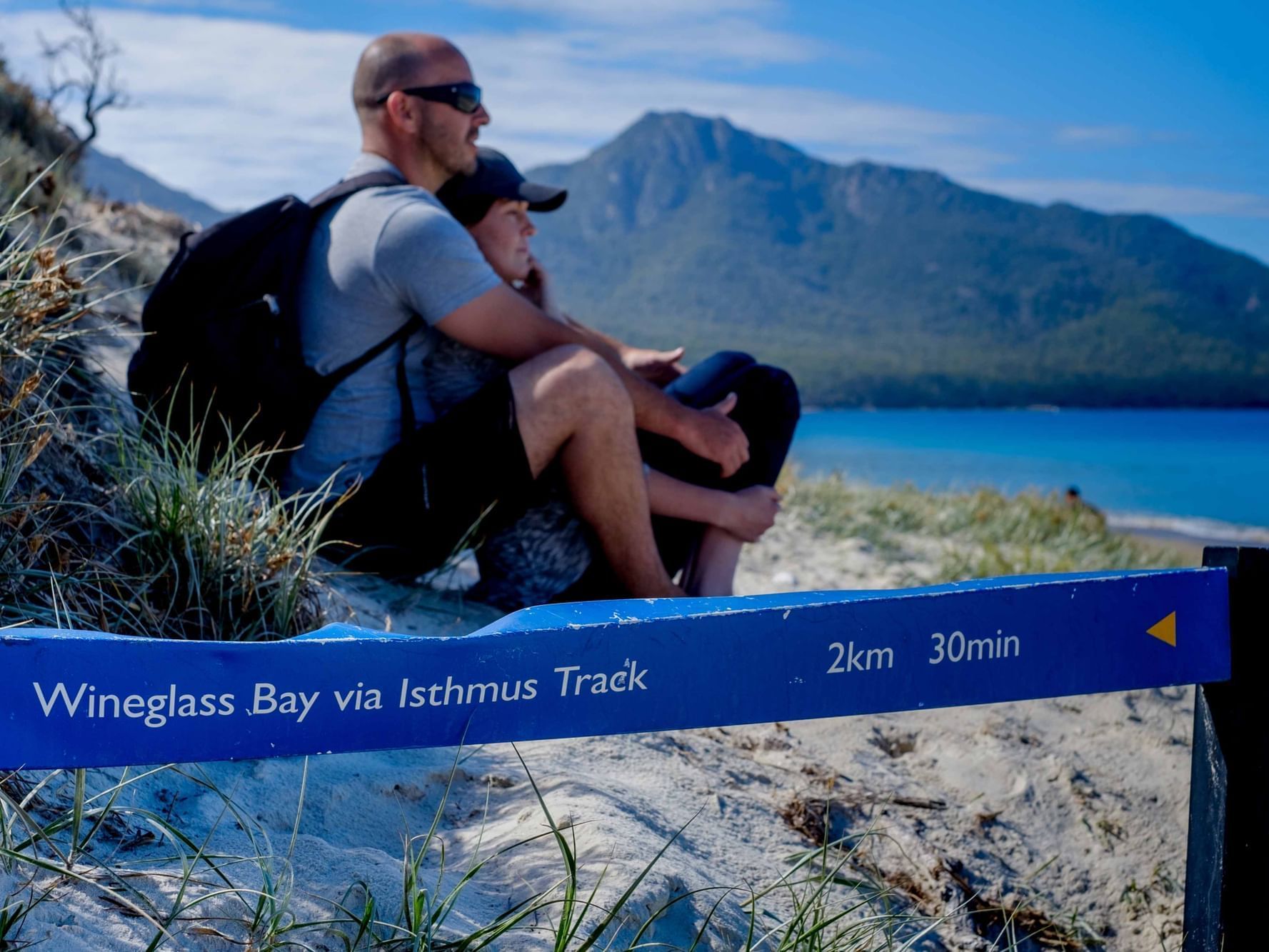 Couple sitting by the beach at the Bay in Freycinet Lodge