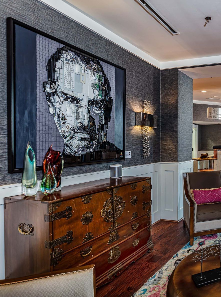 Elegant lobby lounge area with wooden floors & a painting of Steve Jobs in Inn at the Crossroads