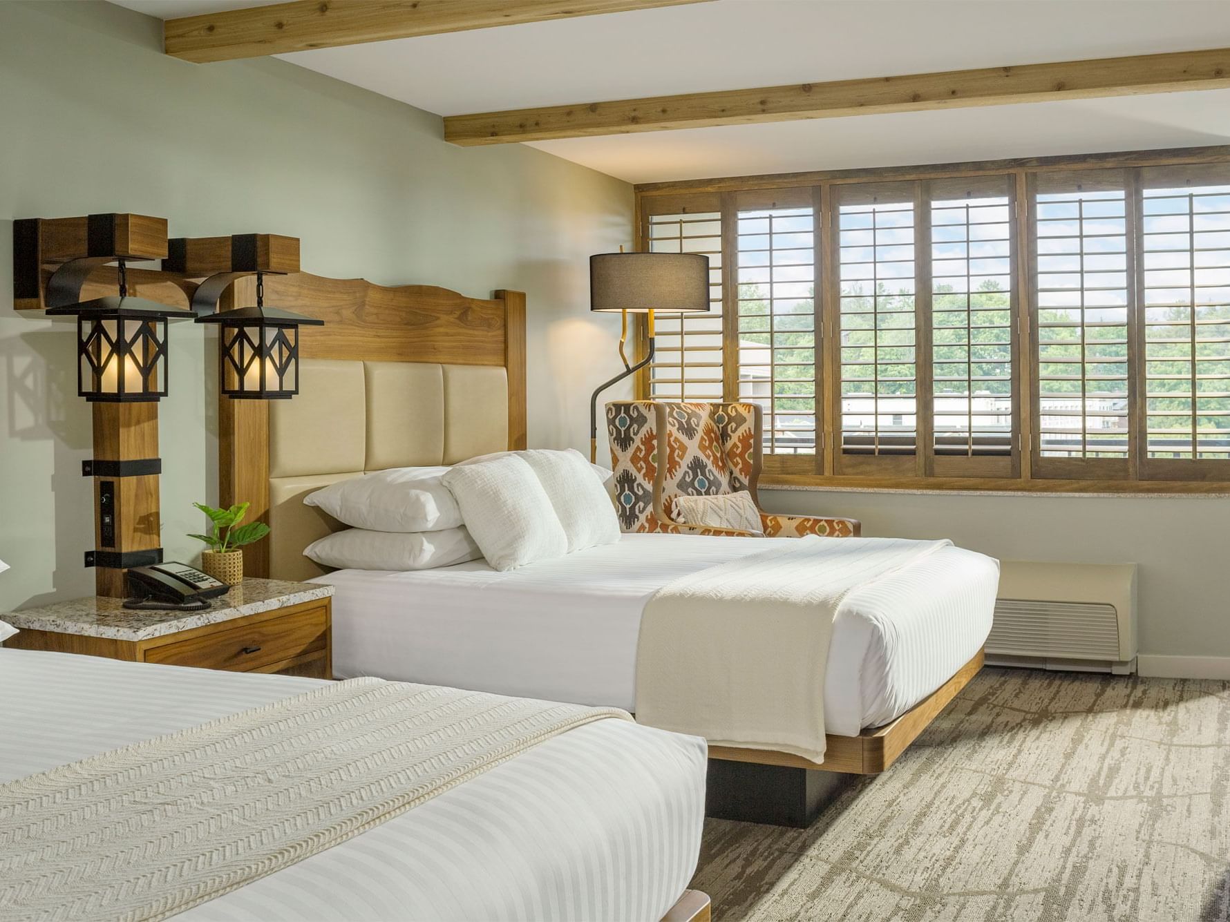 Hotel room with two queen size beds and armchair.