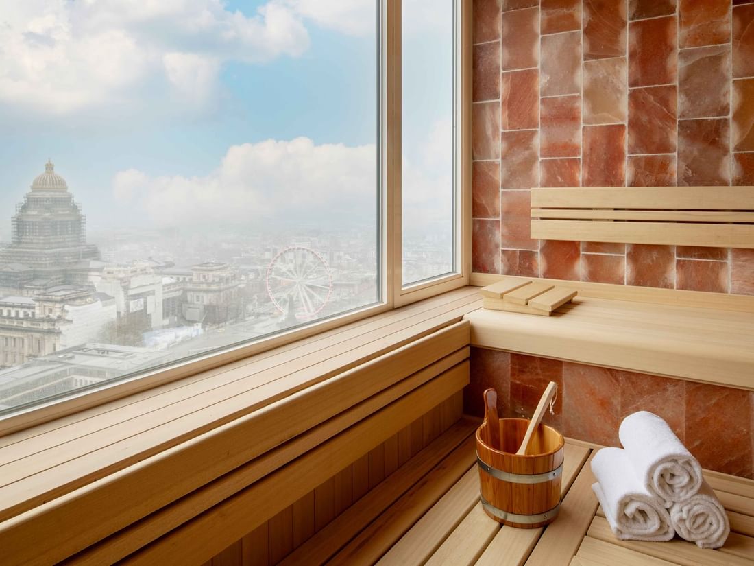 Salle de sauna avec grande fenêtre donnant sur un paysage urbain de la ville de Bruxelles